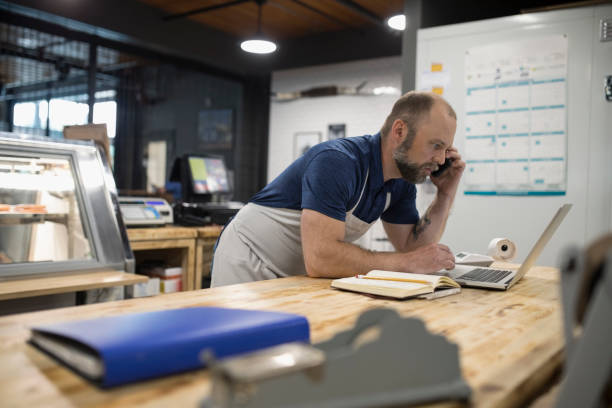 Homme qui consulte son ordinateur portable tout en étant au téléphone